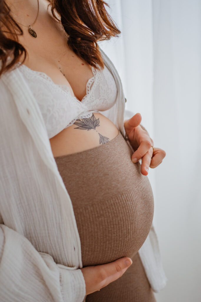 Nahaufnahme von einer Mutter, die sanft über ihren Babybauch streichelt bei einem Babybauchshooting in Kreuzwertheim
